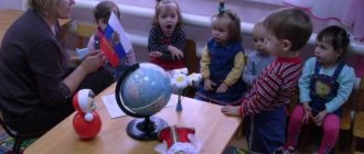 The teacher shows the children the flag of Russia