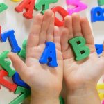 Child holding letters of the English alphabet