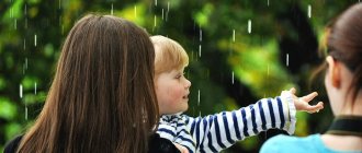 Child under the drops of summer rain